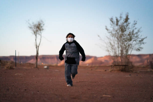 Navajo kid running with face mask during covid-19 quarantine Navajo kid running with face mask during covid-19 quarantine navajo nation covid stock pictures, royalty-free photos & images