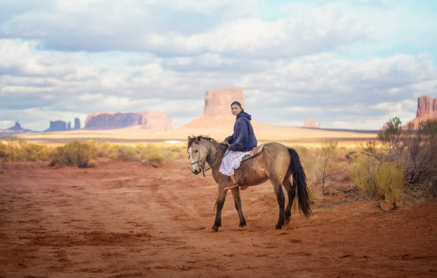navajo infödda amerikansk tonåring ridning i arizonas öknen vid solnedgången - desert cowgirl bildbanksfoton och bilder