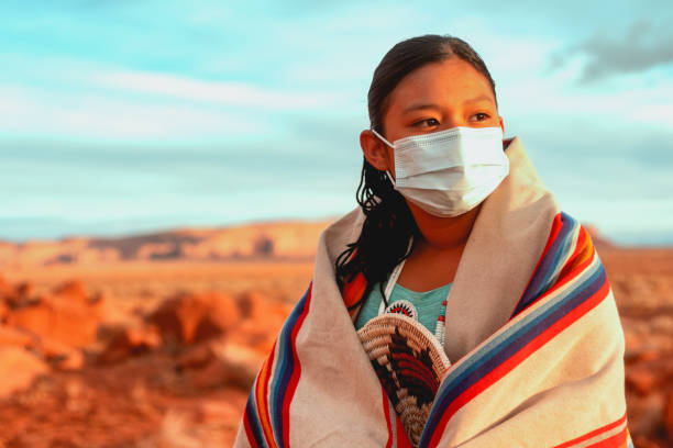 A Navajo Teenage Girl Wearing A Face Mask Wrapped In A Traditional Indian Blanket A Navajo Teenage Girl Wearing A Face Mask Wrapped In A Traditional Indian Blanket navajo nation covid stock pictures, royalty-free photos & images