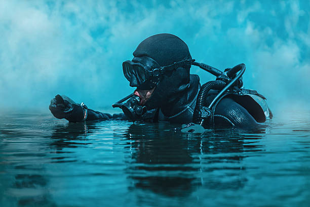 Navy SEAL frogman Navy SEAL frogman with complete diving gear and weapons in the water aqualung diving equipment photos stock pictures, royalty-free photos & images