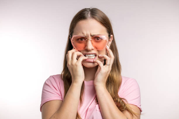 nbeautiful female student shows fussiness befor difficult exams nbeautiful female student shows fussiness befor difficult exams isolated white background. closeup portrait. girl raises the dust. fussiness stock pictures, royalty-free photos & images