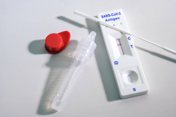 Negative result on a rapid antigen self test kit for covid-19 diagnostic with nasal swabs, tube and detection device, light gray background, copy space, high angle view from above stock photo