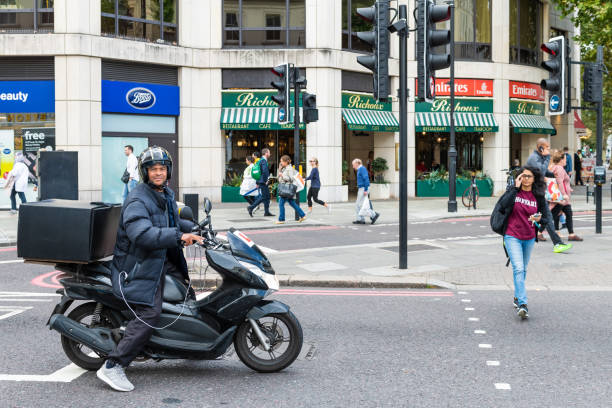район кенсингтон уличный человек на мотоцикле в оживленном дорожном движении с магазинами доставки - fulham стоковые фото и изображения