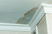 istock Neighbors have a water leak, water-damaged ceiling, close-up of a stain on the ceiling 1301457818