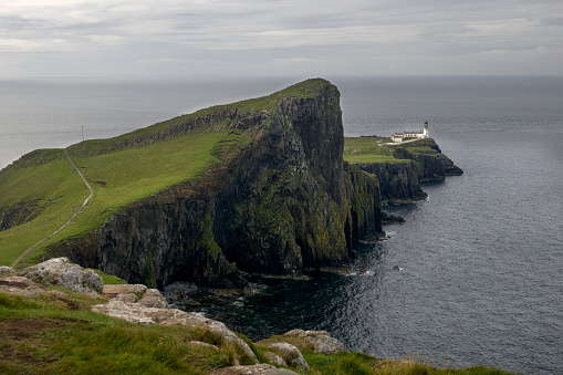 Landscape of cliffs and Neist Point lighthouse on the Isle of Skye in Scotland.