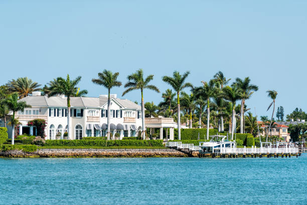 Nelson's Walk white house building with water on Dollar bay, palm trees in residential community, homes in Florida Naples, USA - April 30, 2018: Nelson's Walk white house building with water on Dollar bay, palm trees in residential community, homes in Florida naples florida beach stock pictures, royalty-free photos & images
