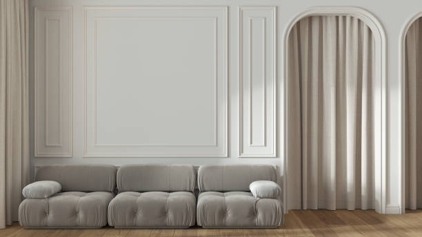 Neoclassic living room, molded walls with copy space, template. Arched door with curtain and parquet floor. White and beige tones, modern velvet sofa. Classic interior design stock photo