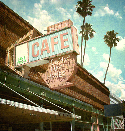 aged and worn neon cafe sign with palm trees
