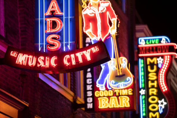 Neon signs along the Broadway in downtown Nashville Tennessee USA Nashville, Tennessee - June 20, 2019:  Colorful neon store signs hang along the bars restaurants and record stores along Broadway Street in downtown Nashville Tennessee USA broadway nashville stock pictures, royalty-free photos & images