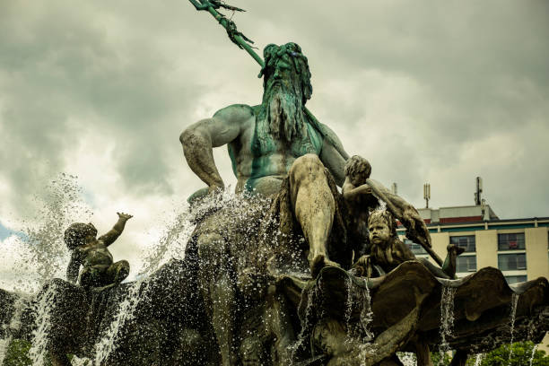 Neptune fountain (Neptune Fountain) on Alexanderplatz in Berlin, Germany Neptune fountain (Neptunbrunnen) on Alexanderplatz, springtime and cloudy weather. poseidon statue stock pictures, royalty-free photos & images