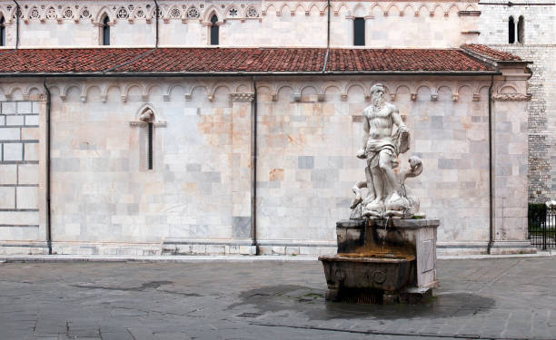 Neptune sculpture A Neptune sculpture in front of the Duomo in Carrara, Tuscany, Italy. poseidon statue stock pictures, royalty-free photos & images