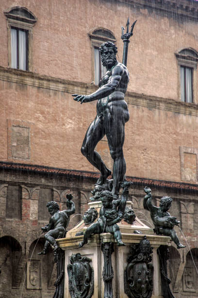 Neptune statue on a rainy day Neptune fountain with rain in front of a facade of an old building in Italy poseidon statue stock pictures, royalty-free photos & images