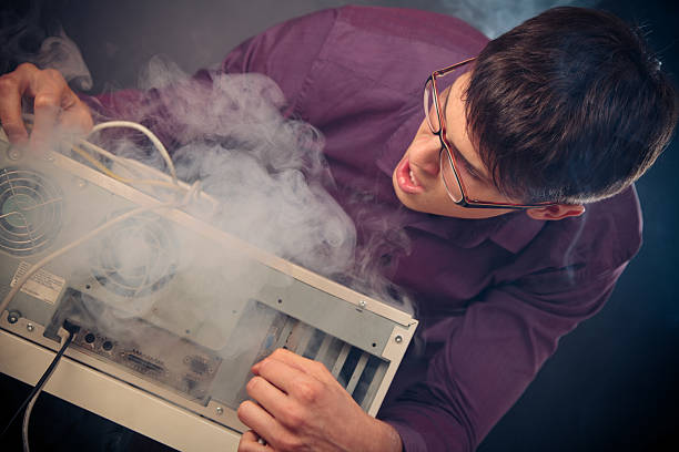 nerd with smoke coming out of his pc stock photo