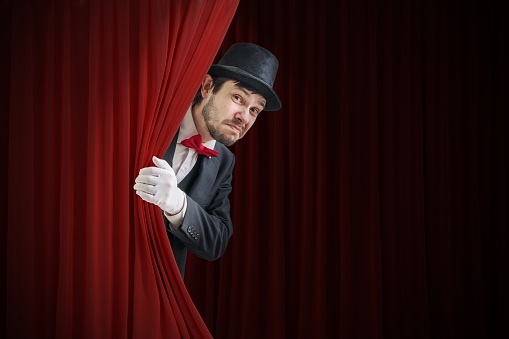 Nervous Actor Or Illusionist Is Hiding Behind Red Curtain In Theater Stock  Photo - Download Image Now - iStock
