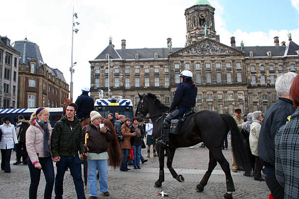 Netherlands: Police in Amsterdam for World Cup Qualifier Amsterdam, Netherlands - March 28, 2009: Mounted police officers in Dam Square to maintain the peace as Scottish soccer fans gather in anticipation of a World Cup qualifying match in Amsterdam. The game was played March 28, 2009 with the Dutch winning 3-0 over Scotland. equipacion fútbol stock pictures, royalty-free photos & images
