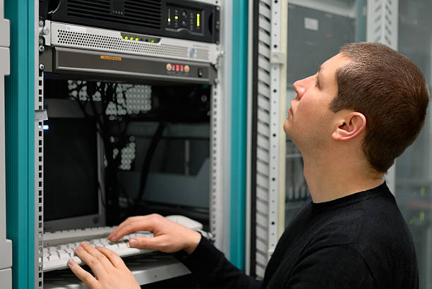 Network technician performs preventive maintenance a server stock photo