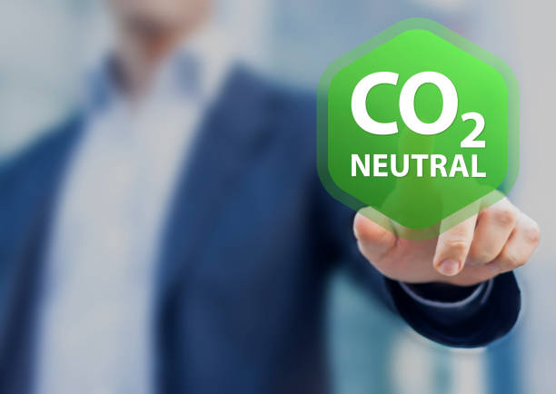 CO2 neutral commitment in business, finance and industry to reduce carbon dioxide emissions and limit global warming and climate change. Concept with person touching button to decarbonize. stock photo