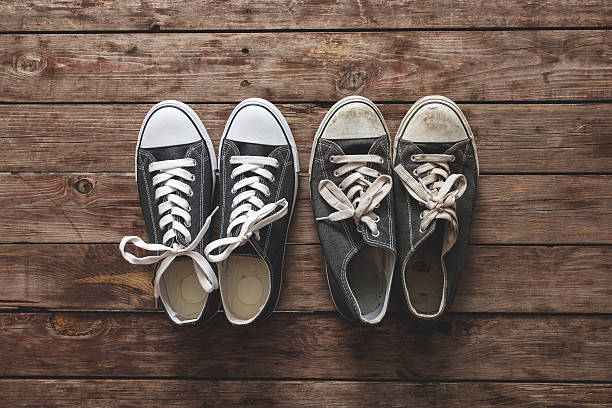 New and old sneakers on wooden background New and old sneakers on wooden background. old vs new stock pictures, royalty-free photos & images