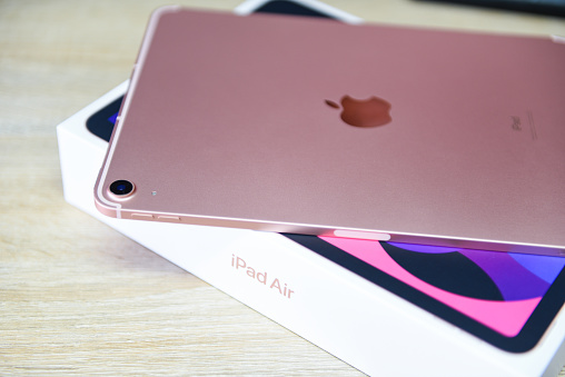 Bangkok, Thailand - August 21, 2021: New Apple iPad rose gold color, camera and rear view logo Apple launch Tablet iPad Air 2020-2021 (4th Gen.) with box on white background