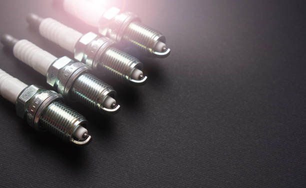 New automobile spark plugs on a dark background with copy space New automobile spark plugs on a dark background with copy space iridium stock pictures, royalty-free photos & images
