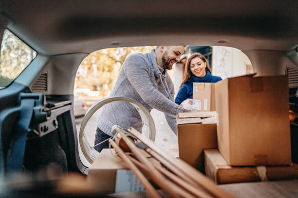 New beginings Young couple moving in new apartment with pick-up truck unpacking stock pictures, royalty-free photos & images