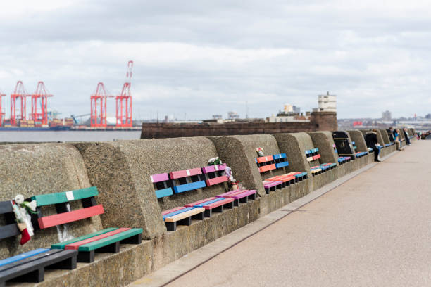 New Brighton Beach Promenade New Brighton Beach Promenade overlooking Liverpool.  Line of multi-coloured park benches along the promenade wall. the wirral stock pictures, royalty-free photos & images