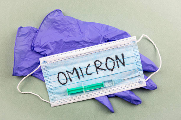 nuovo coronavirus covid-19 mutazione omicron concetto. maschera medica, siringa e testo con lettere omicron. - omicron foto e immagini stock