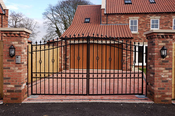 New Gated House New garage and driveway behind an iron gate in a UK housing development.  gate stock pictures, royalty-free photos & images