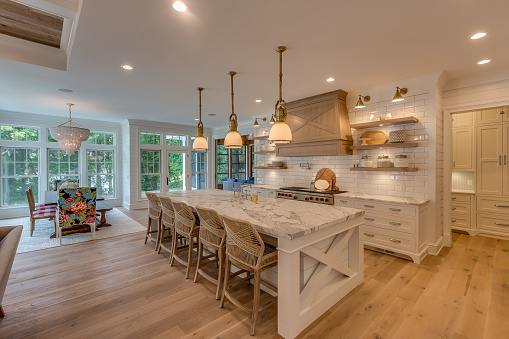 Three pendant lights hang over the island with decorative vent hood over the stove