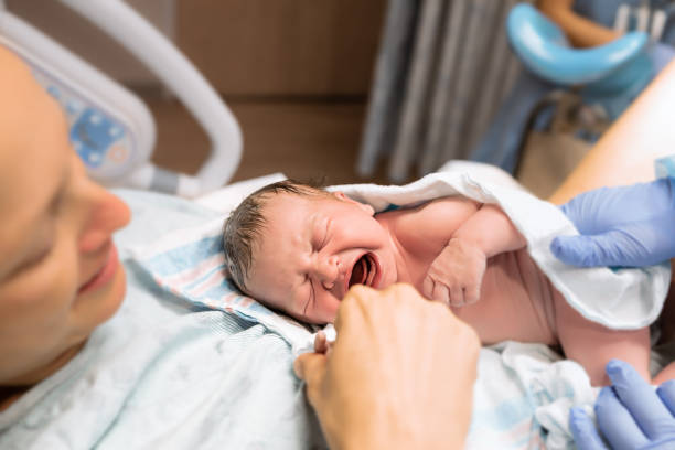 New mom holds her baby in the hospital stock photo