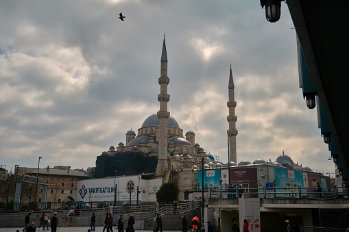 Turkey istanbul 03.03.2021. Yeni Cami mosque in istanbul turkey during morning with flying seagulls witn overcast sky.