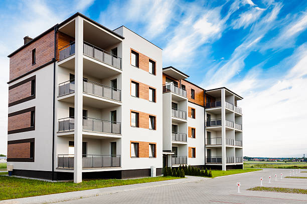 New multi-family block with balconies, bright facade and wooden panels. stock photo