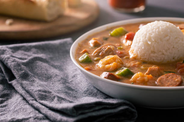 New Orleans Cajun Gumbo With Shrimp, Andouille, and Chicken Traditional New Orleans cajun gumbo with shrimp, andouille sausage, and chicken with rice and hot sauce. gumbo stock pictures, royalty-free photos & images
