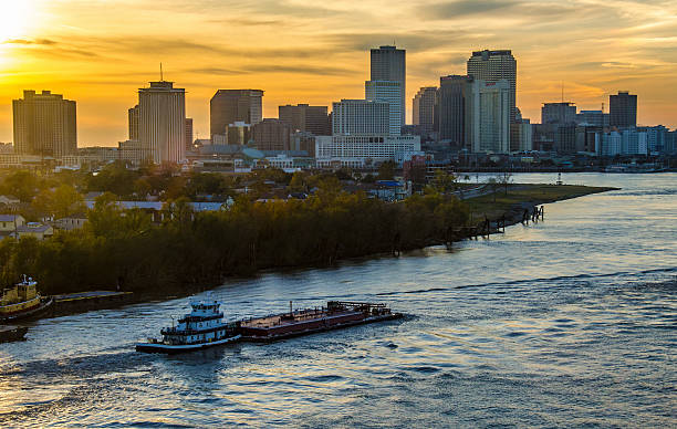 New Orleans Mississippi River Sunset color over New Orleans, Louisiana. barge stock pictures, royalty-free photos & images