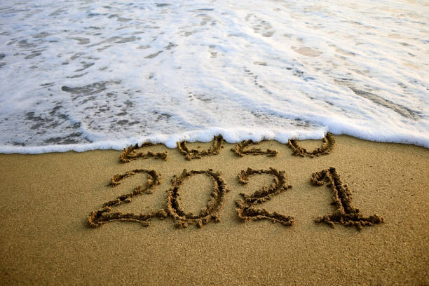 New year 2021 and old year 2020 on sandy beach with waves
