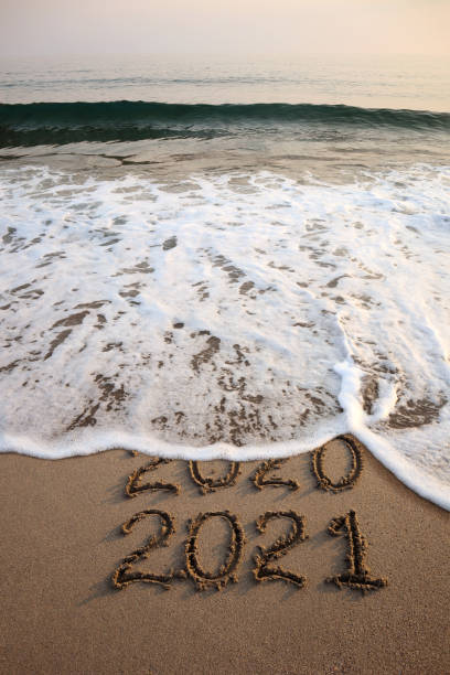 capodanno 2021 e 2020 su spiaggia sabbiosa con onde - fotografia immagine foto e immagini stock