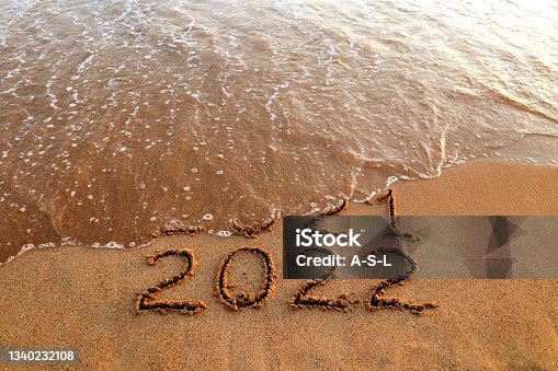 istock New year 2022 and 2021 on sandy beach with waves 1340232108