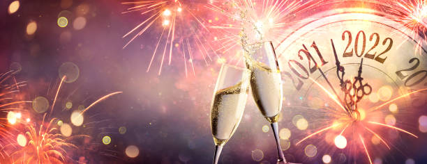 neujahrsfeier 2022 - toast mit champagner und feuerwerk - romolotavani stock-fotos und bilder