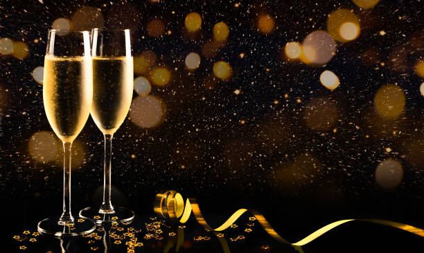 New year celebration with champagne Two glasses of champagne with golden confetti, glitter, serpentine and lights. Night of celebration concept champagne stock pictures, royalty-free photos & images