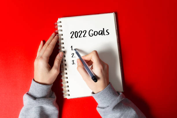 2022 new year goal, plan, action text written on notebook. stock photo