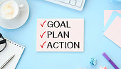 istock 2022 New Year. Goal,plan, action text on notepad with office accessories on a wooden background. Business motivation, inspection concepts ideas. 1360187682