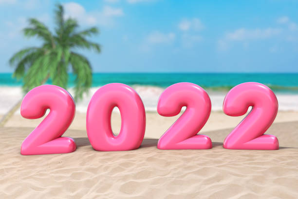 New Year Vacation Concept. Pink 2022 Happy New Year Sign on an Ocean Deserted Coast. 3d Rendering stock photo