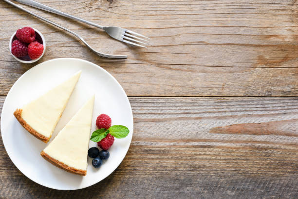 new york cheesecake oder klassischen käsekuchen mit frischen beeren auf weißen teller - käsekuchen stock-fotos und bilder