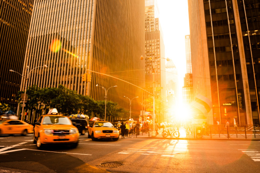 Yellow cab is rushing trough the city in the sunset time. Manhattan, New York City, US.