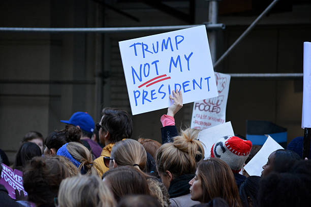 New York City New York, New York - November 12, 2016: Protester carrying a sign while marching in a "Trump is not my President" rally in response to the 2016 Presidential Election of Donald Trump in New York City in 2016. donald trump stock pictures, royalty-free photos & images