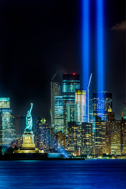 New York City skyline and Statue of Liberty on 911 This is a view of the Manhattan skyline and the Statue of Liberty on the night of September 11, 2015.  The 911 memorial lights can be seen in the background. september 11 2001 attacks stock pictures, royalty-free photos & images