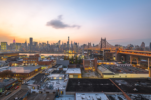 Queens, New York, USA view with the Queensboro Bridge towards Manhattan at dusk.