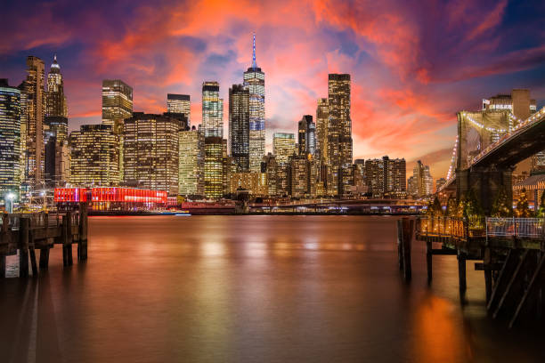 New York City Skyline with Brooklyn Bridge, Manhattan Financial District and World Trade Center with Dramatic Sunset Sky. stock photo