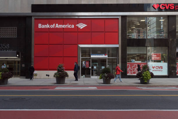 New York during the COVID-19 emergency. Manhattan, New York. October 08, 2020. Two men wearing a face mask walk by the entrance of a Bank of America in Midtown. bank of america stock pictures, royalty-free photos & images