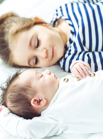 Adorable newborn and her toddler sister together at home